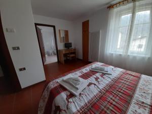 a bedroom with a bed with two towels on it at Albergo Centrale in Carbonare di Folgaria