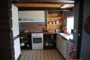 a kitchen with a white stove and a sink at Duvan in Dals Långed