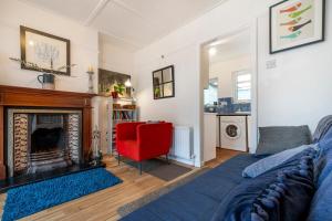 a living room with a fireplace and a red chair at Cosy and central Belfast House in Belfast