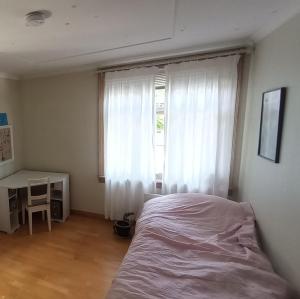 a bedroom with a bed and a desk and a window at Room2B in Bergen
