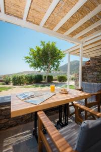 Ein Holztisch und Stühle auf einer Terrasse mit Aussicht in der Unterkunft Apelagitis 3 in Sifnos