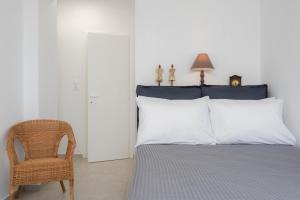 ein Schlafzimmer mit einem Bett und einem Stuhl in der Unterkunft Apelagitis 3 in Sifnos