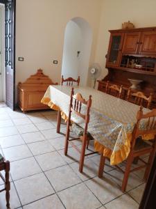 a dining room with a table and chairs and a piano at Sunset House in Castro di Lecce