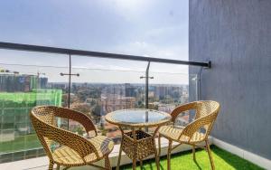 a table and chairs on a balcony with a view at Vibyqa cosy and vibes in Nairobi +3 photos