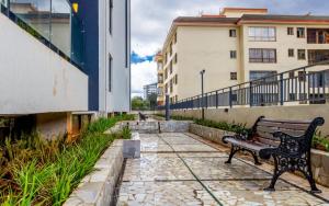a bench sitting on a sidewalk next to a building at Vibyqa cosy and vibes in Nairobi