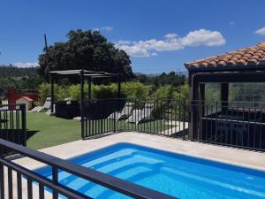 a swimming pool in a yard with a gazebo at Casa Rural La Casita Roja in Burgohondo