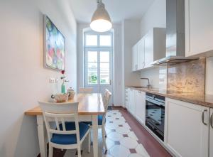 a kitchen with a table and chairs and a kitchen with white cabinets at Rooms GUT HEIDEFELD in Bocholt