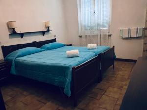 1 dormitorio con 1 cama grande con sábanas azules y ventana en Albergo Belvedere, en Maissana