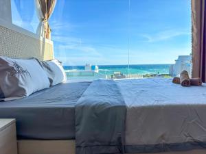 a bedroom with a large bed with a view of the ocean at La Min Home - Nguyên Căn View Biển Đảo Phú Quý in Cu Lao Thu