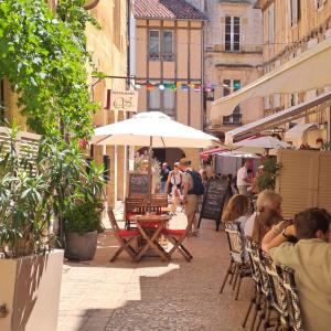 a group of people sitting on a street with umbrellas at Les Cœurs de Ribérac - Hyper centre - Climatisation - Wi-Fi in Ribérac