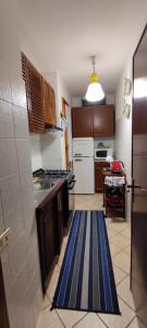 Una cocina con una alfombra azul y blanca en el suelo. en condominio Brembo a casa di Barbara, en Foppolo