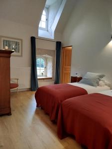 a bedroom with two beds and a window at Les Communs de Chiffrevast in Tamerville