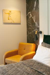 a bedroom with a bed and a couch and a chair at Beach Apartment in Batumi