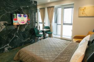 a hotel room with a bed and a tv on a wall at Beach Apartment in Batumi +43 photos