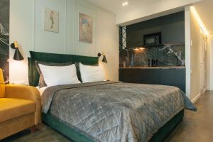 a bedroom with a large bed and a yellow couch at Beach Apartment in Batumi