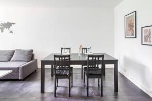a dining room table with chairs and a couch at Appartement Moderne, À la Passerelle des Trois Pays, HUNINGUE CENTRE in Huningue