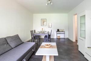 a living room with a couch and a table at Appartement Moderne, À la Passerelle des Trois Pays, HUNINGUE CENTRE in Huningue