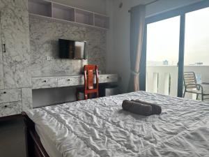 a bedroom with a bed with a television on the wall at Ranisa Kampot in Kampot