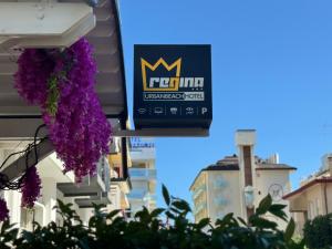 a sign on the side of a building with purple flowers at Regina Urban Beach Hotel in Lido di Jesolo