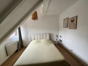 Un dormitorio con una cama grande en un ático. en Au théâtre, en Colmar