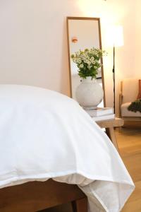 ein Schlafzimmer mit einem weißen Bett und einem Spiegel in der Unterkunft Brooklyn Hideaway in Brooklyn