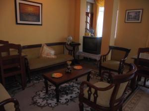 a living room with a couch and chairs and a tv at Chimborazo in Riobamba