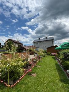 a garden with flowers and a building in the background at Penzión u Veroniky in Ždiar