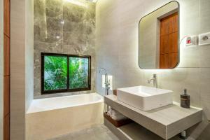a bathroom with a sink and a tub and a window at Bramasta Villa in Ubud +17 photos