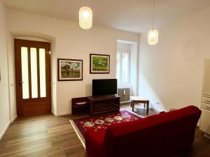 a living room with a red couch and a television at Santa Massenza Vineyard Escape in Santa Massenza