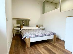 a small bedroom with a bed and a staircase at Santa Massenza Vineyard Escape in Santa Massenza