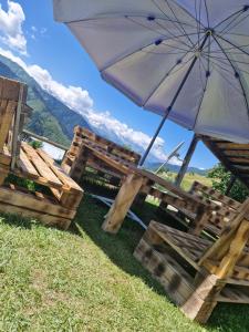 a table and chairs with an umbrella in the grass at Maia's Guesthouse in Mestia