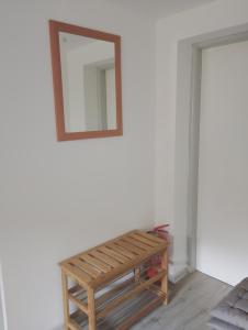 Un espejo colgado en una pared al lado de un banco. en Apartmán KPS, en Kalameny 4 fotos más