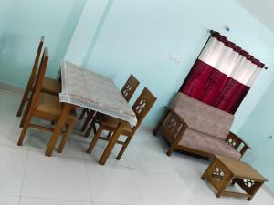 a room with chairs and a table and a curtain at Royal 2 Bed Room Apartment -Opp Mattuthavai Bus stand Madurai in Madurai