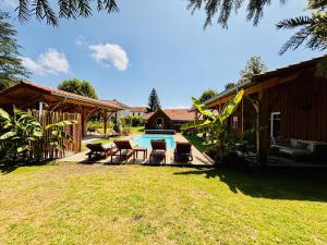 a backyard with a swimming pool and a house at Villa La Forge in Parentis-en-Born