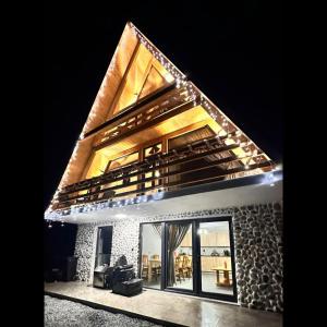 a house with lights on top of it at night at A Frame Panoramic Dundy 