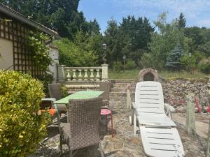 a patio with a table and chairs in a yard at l'Etable des Arts in Tillières-sur-Avre