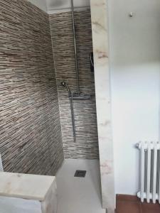 a shower in a bathroom with a stone wall at Hostal Restaurant Sant Marçal in Amer