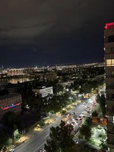 une ville la nuit avec des voitures garées dans une rue dans l'établissement Панорамная евродвушка комфорт-класса, à Almaty