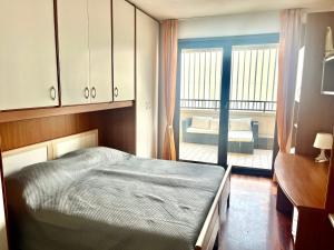 Un dormitorio con una cama y un balcón. en Appartamento Spigola vista Laguna, en Grado