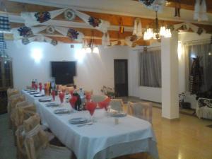 a long table with a white table cloth and chairs at Pensiunea Georgiana in Şieu