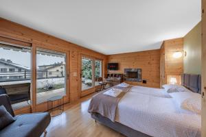 a bedroom with a large bed and a large window at Ride Inn Verbier - B&B - private room and ensuite bathroom in Verbier