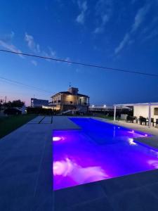 a swimming pool with purple lights in front of a building at Villa Luja in Arielli