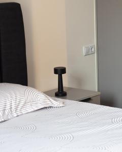 a bedroom with a bed with a mirror and a chair at Ohanas Apartment in Prishtinë +4 photos