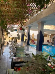 a hotel lobby with a swimming pool and chairs at Triangle Pyramids Boutique in Giza