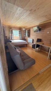 una camera da letto con un letto e un divano in una stanza di Bryn Bettws Lodge a Port Talbot