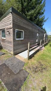 una cabina di legno con recinzione in un campo di Bryn Bettws Lodge a Port Talbot Altre 67 foto