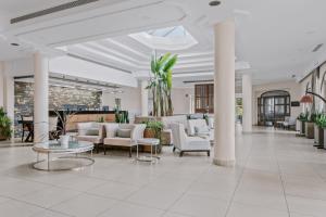 a lobby with couches and chairs in a building at Almyra Resort in Koutsounari