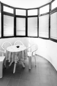 a table and chairs in a room with windows at Apartman Ulcinj in Ulcinj