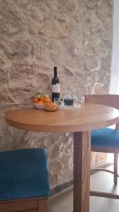 un tavolo in legno con una bottiglia di vino e un cesto di frutta di Agave apartments a Stara Baška Altre 9 foto
