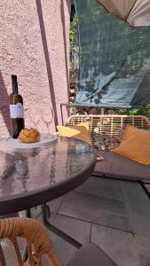 a table with a bottle of wine and a plate of food at Agave apartments in Stara Baška